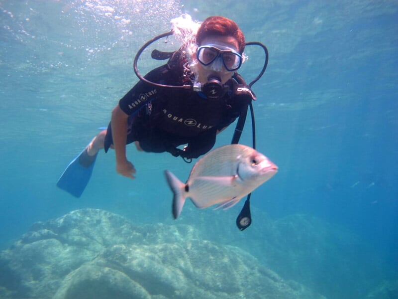 Homme faisant de la plongée sous marine à côté d'un poisson