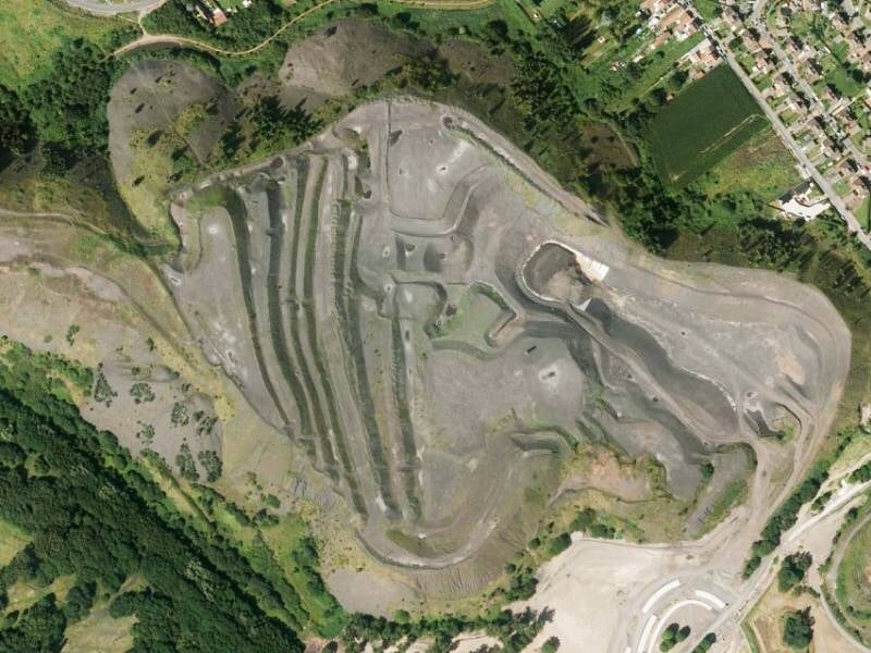 Vue aérienne du terrain de Hénin-Beaumont entouré de végétation et d'habitations.