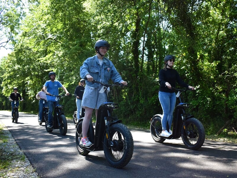 un groupe roule sur une route à trottinette