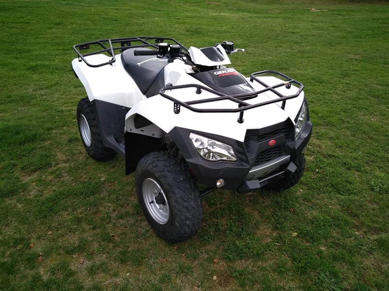 Un quad blanc rutilant sur une herbe verte.