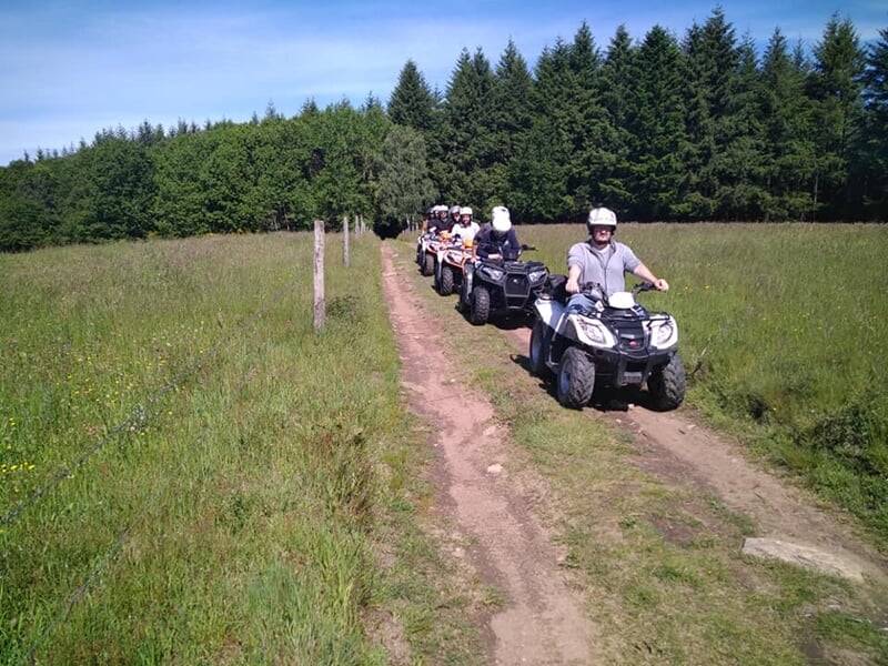 Sur un chemin de campagne, un groupe de quad roule à la file indienne.