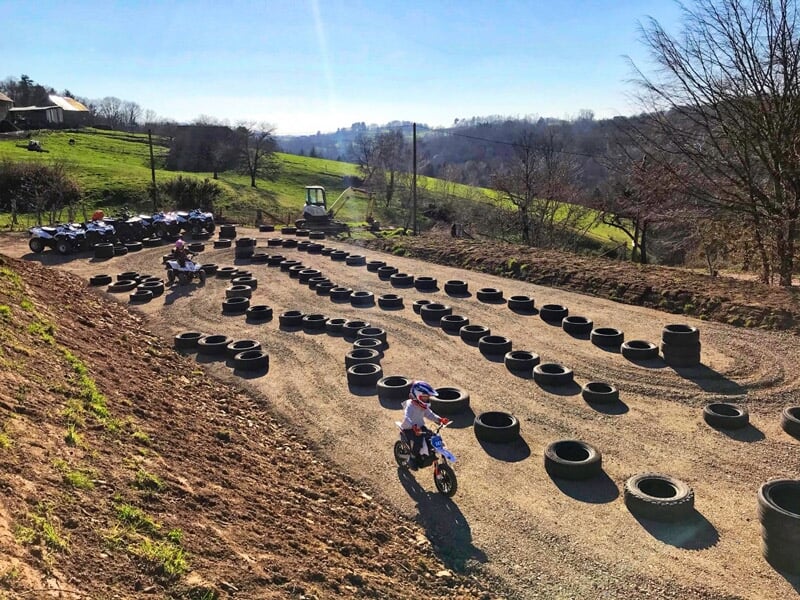 Circuit de quad en plein air avec des pneus disposés en ligne pour délimiter le parcours sur un terrain en pente.