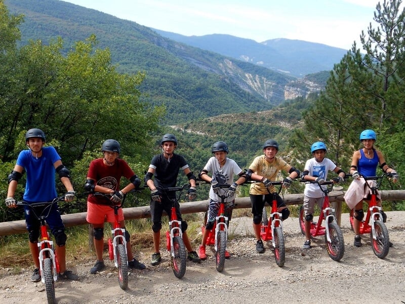 des randonneurs en trottinette posent sur le bord de la route