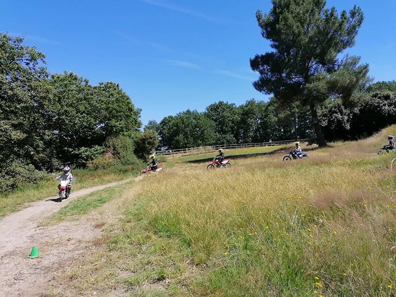Des jeunes pilotes de motocross enchaînent les tours de piste sur un circut école