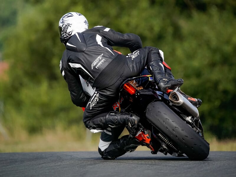 deux personnes en combinaison noire sur une moto de course vues de dos