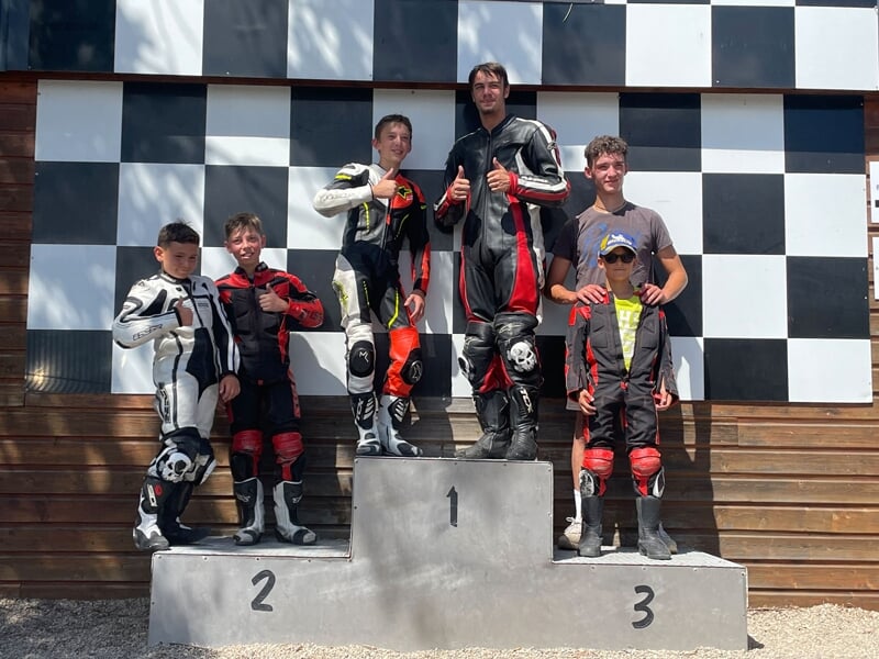 un groupe d'enfants et d'adultes posent sur un podium