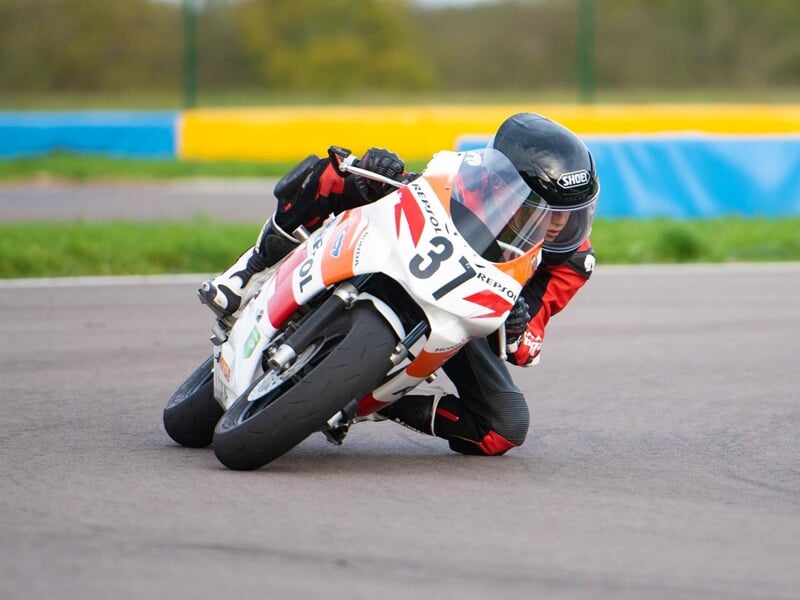 une moto blanche en plein virage sur un circuit