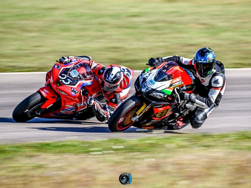 deux pilotes de moto sur des motos de compétition en plein virage sur une piste de course