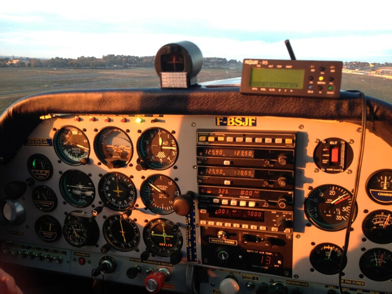Tableau de bord d'un avion avec plusieurs instruments de vol et commandes visibles.