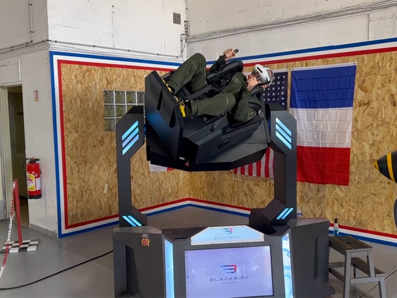 Personne inclinée en arrière dans le simulateur de vol gyroscopique, en pleine simulation de manœuvre.