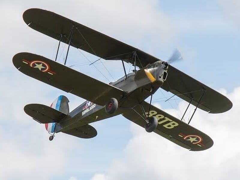 Avion biplan militaire vintage en vol, vu de dessous lors d'un vol en avion Stampe à Cergy.