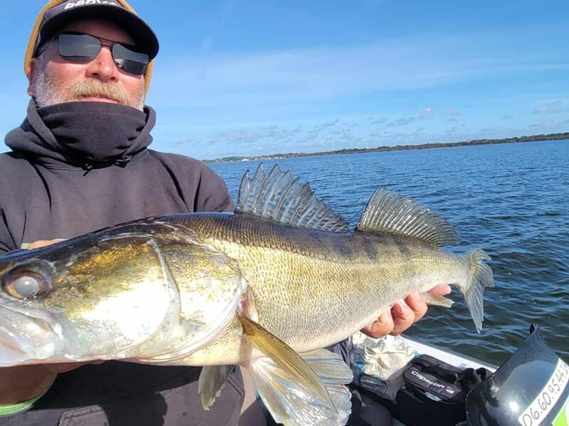 Pêcheur tenant un gros poisson lors d'un séjour avec un guide de pêche sur les lacs des Landes.