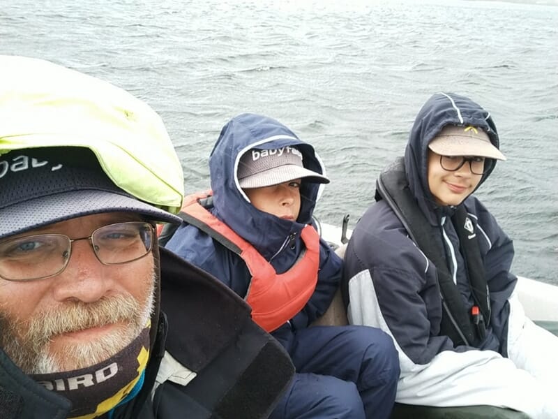 Trois personnes en tenue de pêche avec gilets de sauvetage lors d'un stage de pêche pour enfant sur les lacs des Landes.