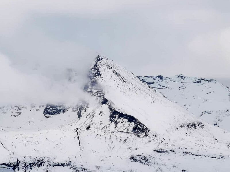 Montagne enneigée avec sommet partiellement caché par des nuages dans le massif de Val Cenis.