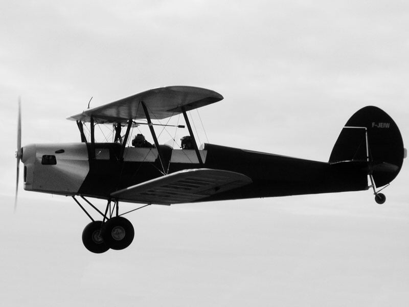 photo en noir et blanc du biplan stampe en vol