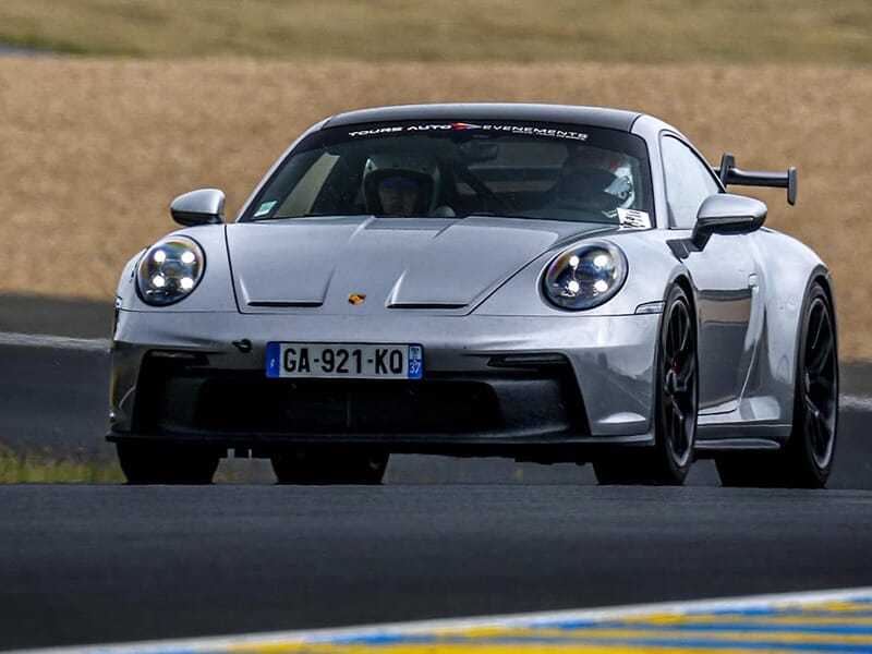 Porsche GT3 argentée capturée de face, laissant entrevoir son design agressif et aérodynamique.