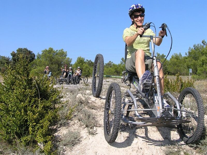 Groupe de personnes en quadricycles tout terrain sur un chemin de terre entouré de végétation dense.