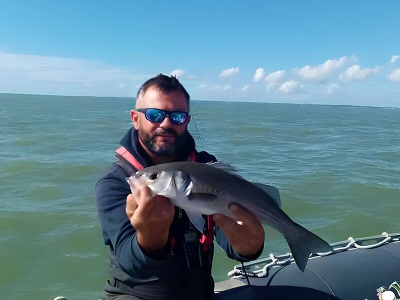 le moniteur de pêche pose avec sa prise