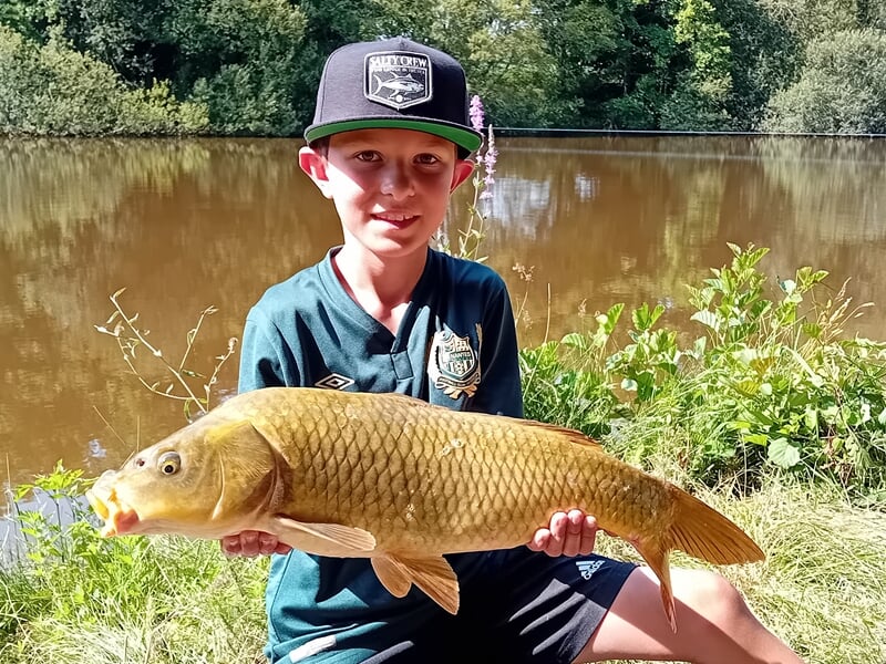 Enfant présentant un carpeaux après une activité pêche