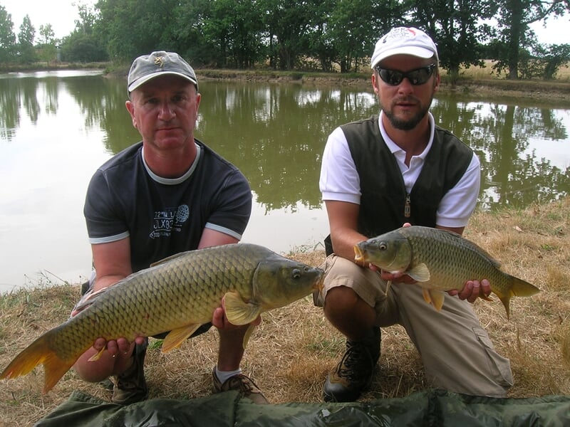 Deux hommes présentant de très belles carpes après la pêche