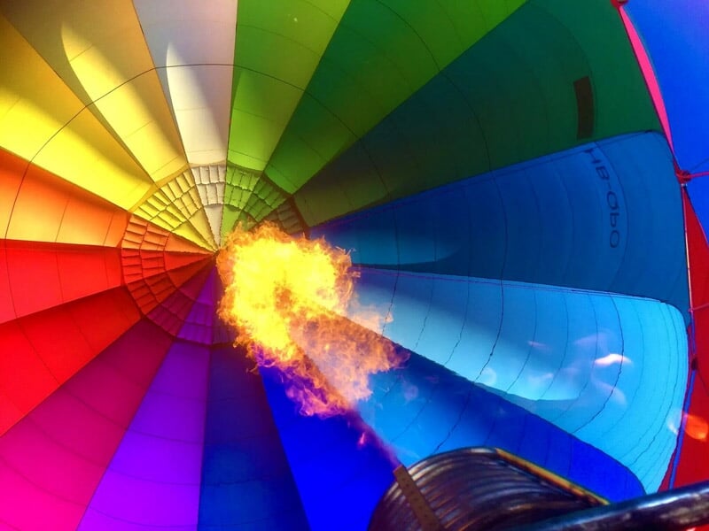Intérieur coloré d'une montgolfière avec la flamme du brûleur en action.