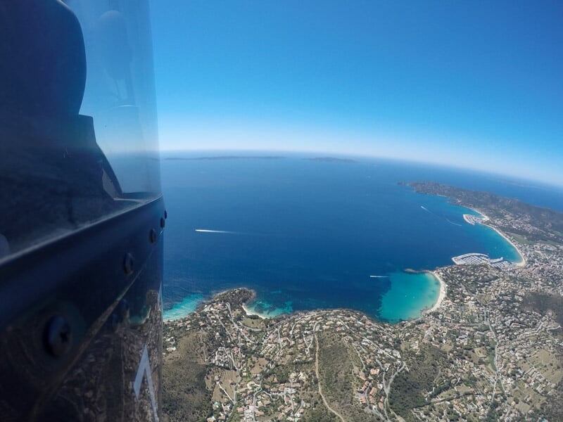 Vue aérienne depuis un hélicoptère sur la côte méditerranéenne avec mer bleue et plages dorées.