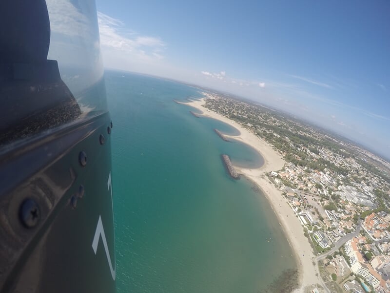 Côte avec plages et petites baies vues en vol depuis un hélicoptère au-dessus de la mer.