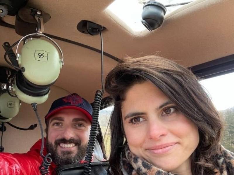 deux personnes posent dans le cockpit d'un hélicoptère avec le sourire aux lèvres
