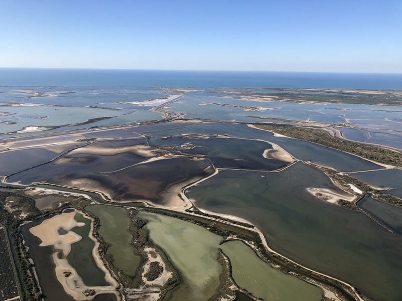 Vue aérienne des étendues d'eau et des marais salants près de l'aérodrome de Nîmes Courbessac sous un ciel clair