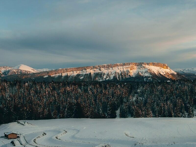 Montagnes enneigées avec sommets et vallées sous un ciel bleu clair et lumineux.