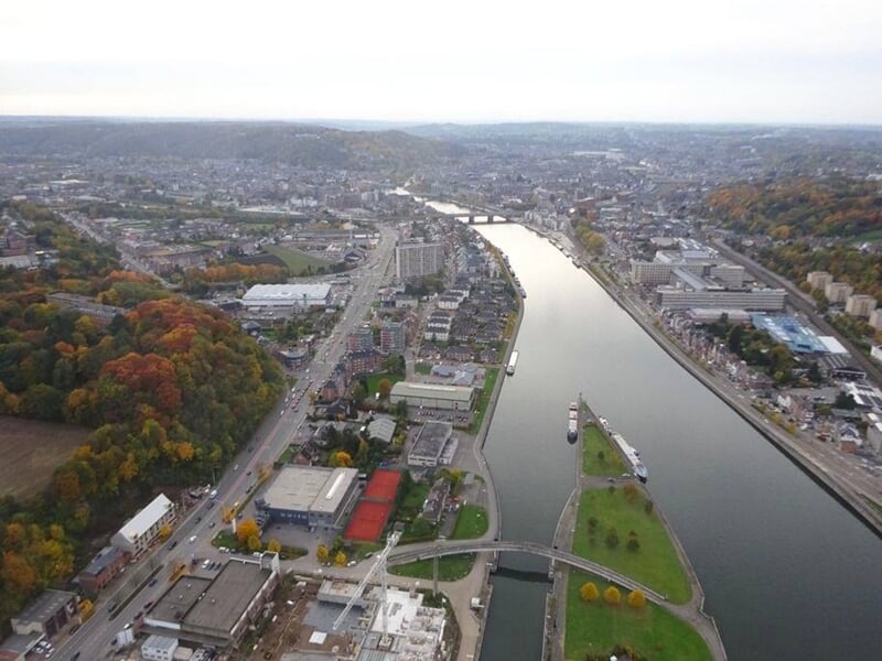 Vue aérienne d'une ville traversée par une rivière avec des ponts et des bâtiments urbains.