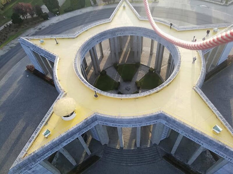 Vue aérienne d'un monument circulaire avec colonnes et une cour intérieure depuis une montgolfière.