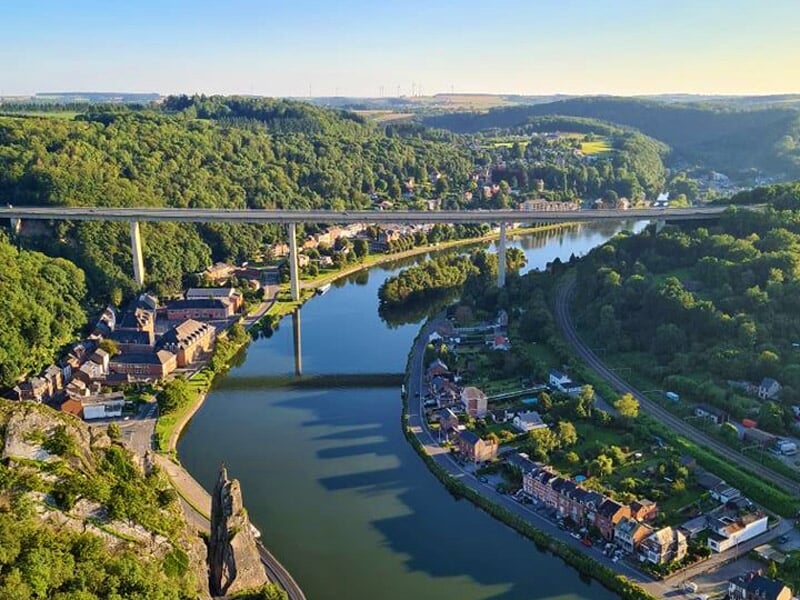Deux montgolfières colorées dégonflées sur une pelouse verte avec un homme assis à proximité.