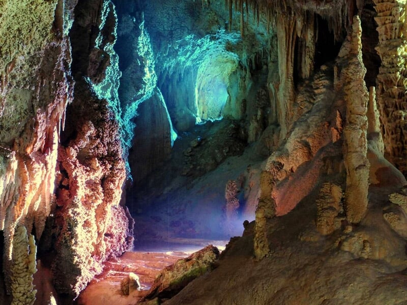 Vue d'une grotte avec des formations rocheuses naturelles et une lumière bleue au fond