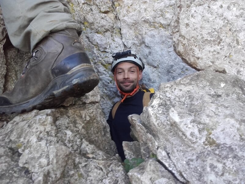 Gros plan sur des stalactites fines et longues suspendues au plafond d'une grotte naturelle.
