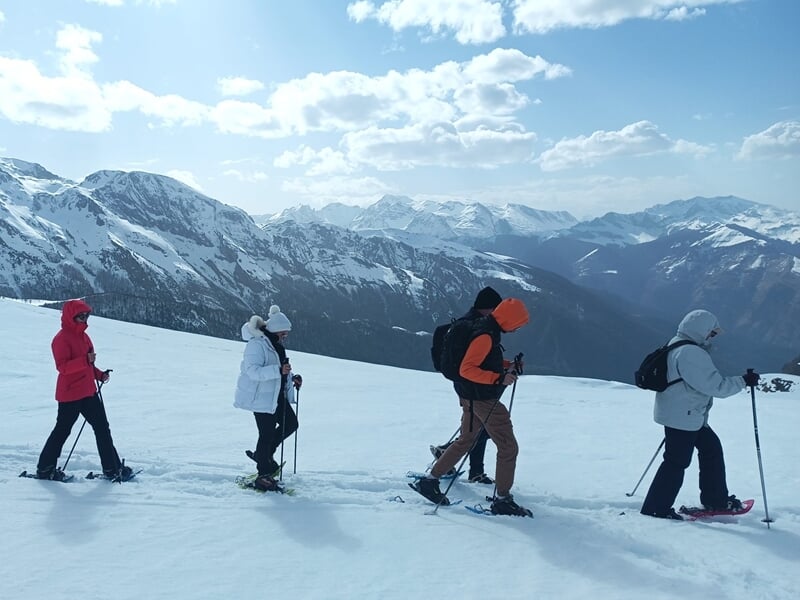 Groupe de personnes pratiquant les raquettes en montagne