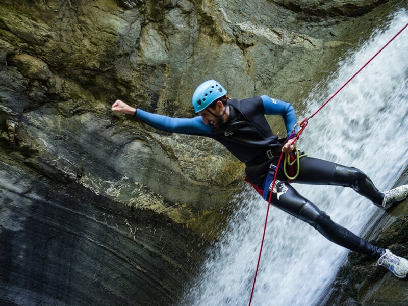 Descente en rappel à côté d'une cascade au canyon du Bitet