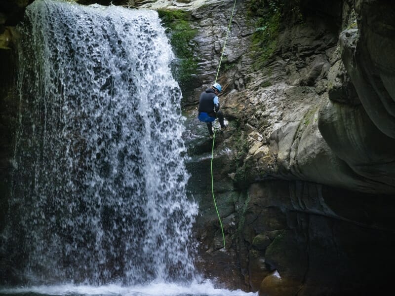 Descente en rappel à côté d'une cascade au canyon du Bitet