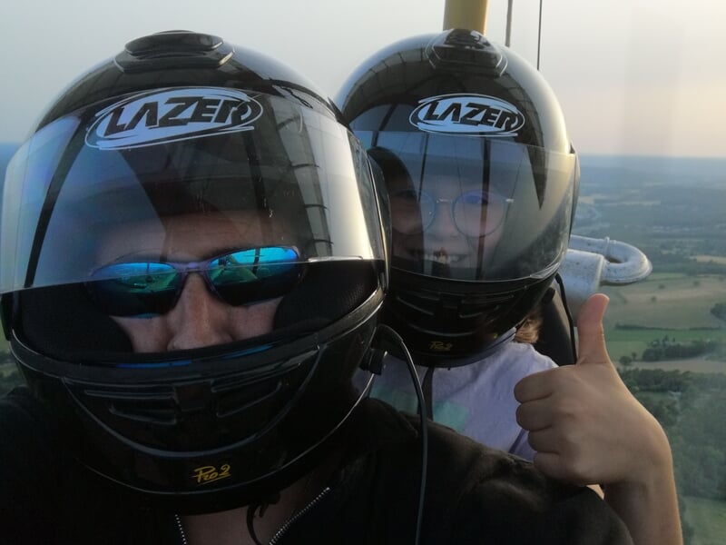 gros plan sur un pilote et sa passagère à bord d'un ULM pendulaire en plein vol