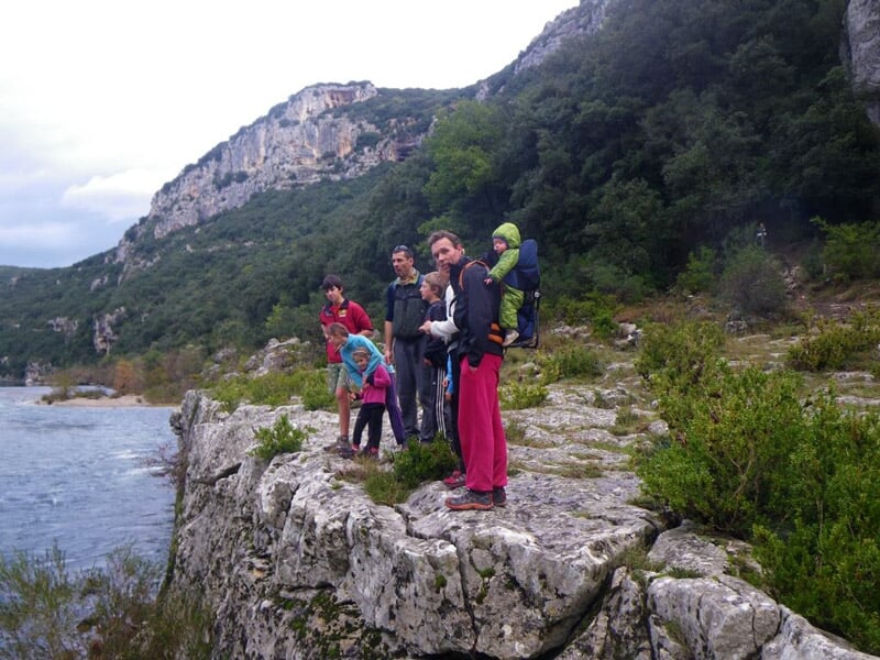Groupe de personnes observant un paysage naturel depuis un point de vue en hauteur.