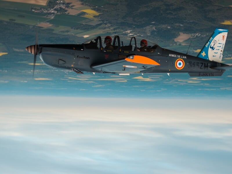 Avion de chasse français gris avec deux pilotes visibles en vol, durant un baptême en avion d'entrainement militaire près de Paris