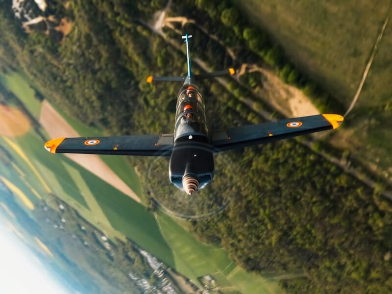 Avion militaire gris vu de face en vol, durant un baptême en avion d'entrainement militaire près de Paris