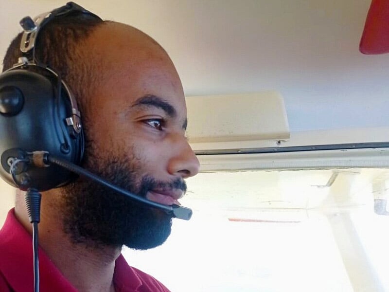 Homme portant un casque avec micro, concentré, probablement pilote lors d'une initiation au pilotage d'avion à Rouen.
