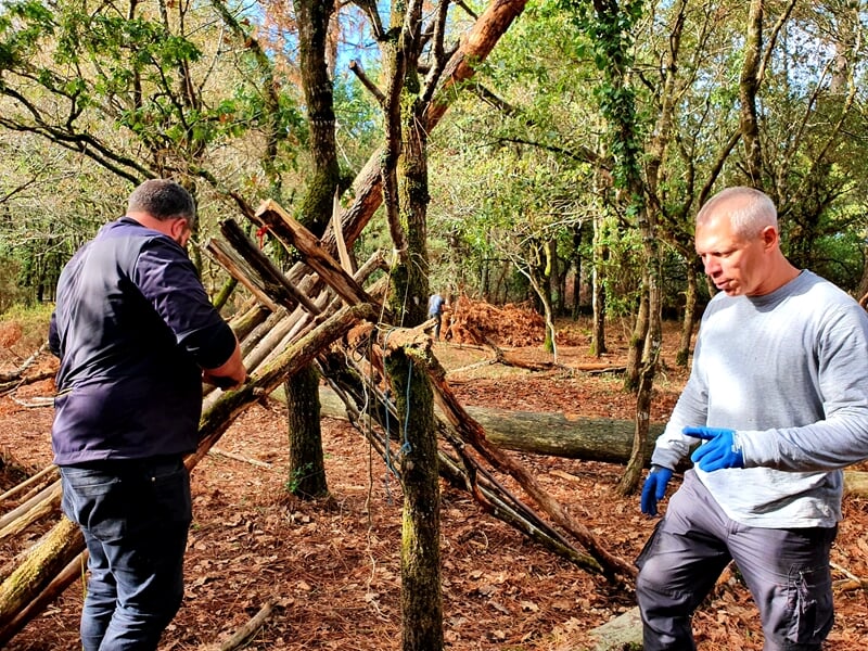 Deux personnes créant un abri lors d'un stage de survie