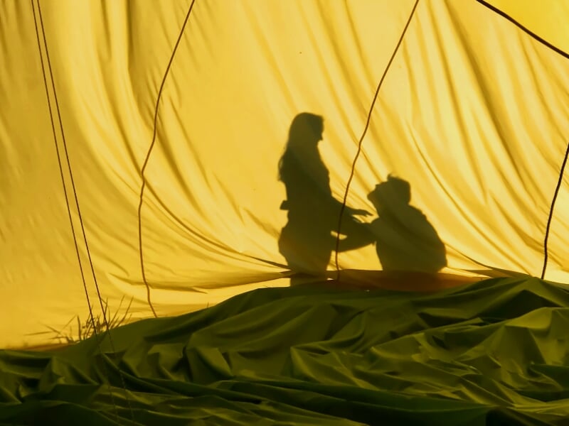 silhouette d'un couple derrière une enveloppe de montgolfière qui se demande en mariage