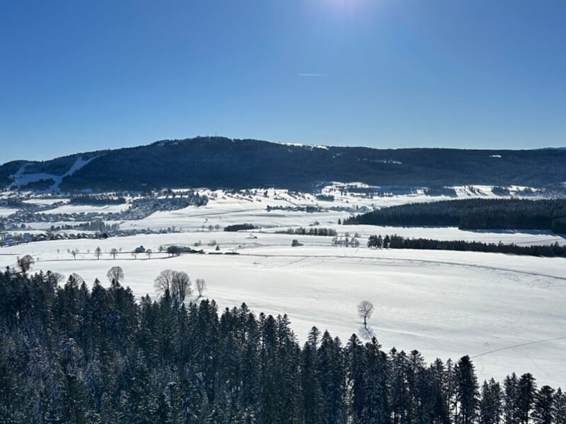 Paysage hivernal avec une vaste étendue enneigée, lors d'un vol en montgolfière près de Métabief.