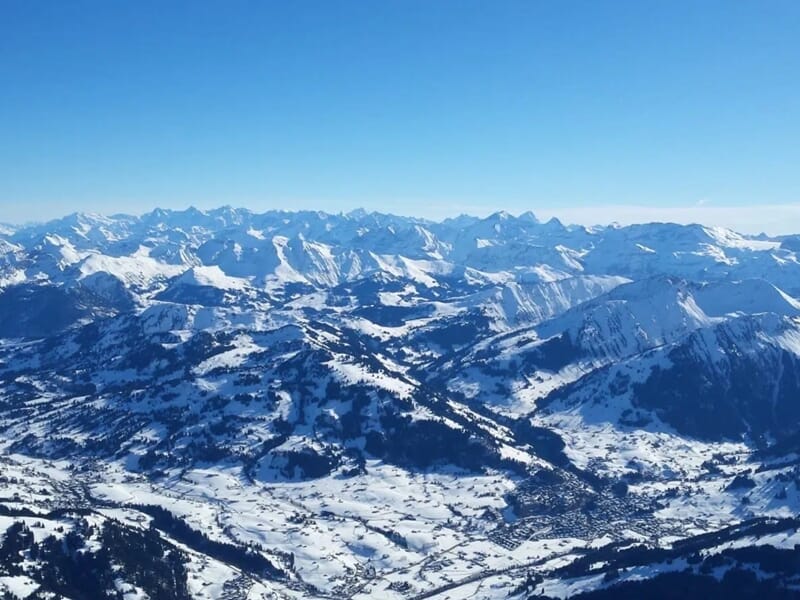 Vue aérienne d'un paysage montagneux enneigé lors d'un vol en montgolfière dans le Chablais.