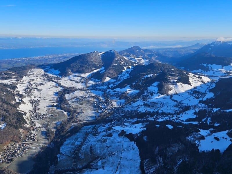 Paysage hivernal vu du ciel montrant des montagnes enneigées, lors d'un vol en montgolfière dans le Chablais.