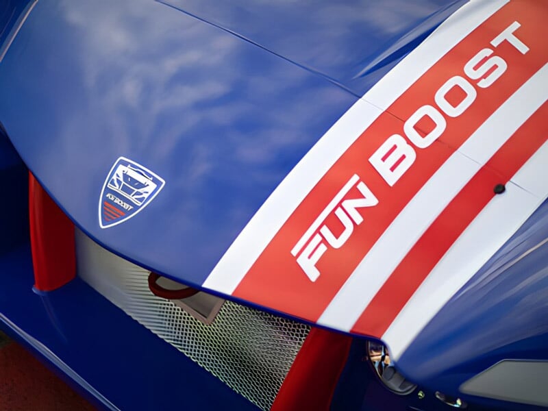 Gros plan sur le capot bleu d'une voiture de course avec inscription Fun Boost et logo distinctif.