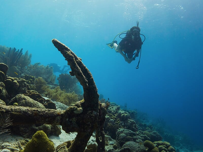 Une plongeuse fait une randonnée palmée dans les eaux limpides de la mer Méditerranée en observant les coraux